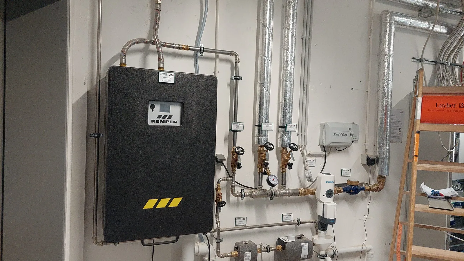 Trinkwasserstation an der Wand mit Armaturen und Wasserzähler